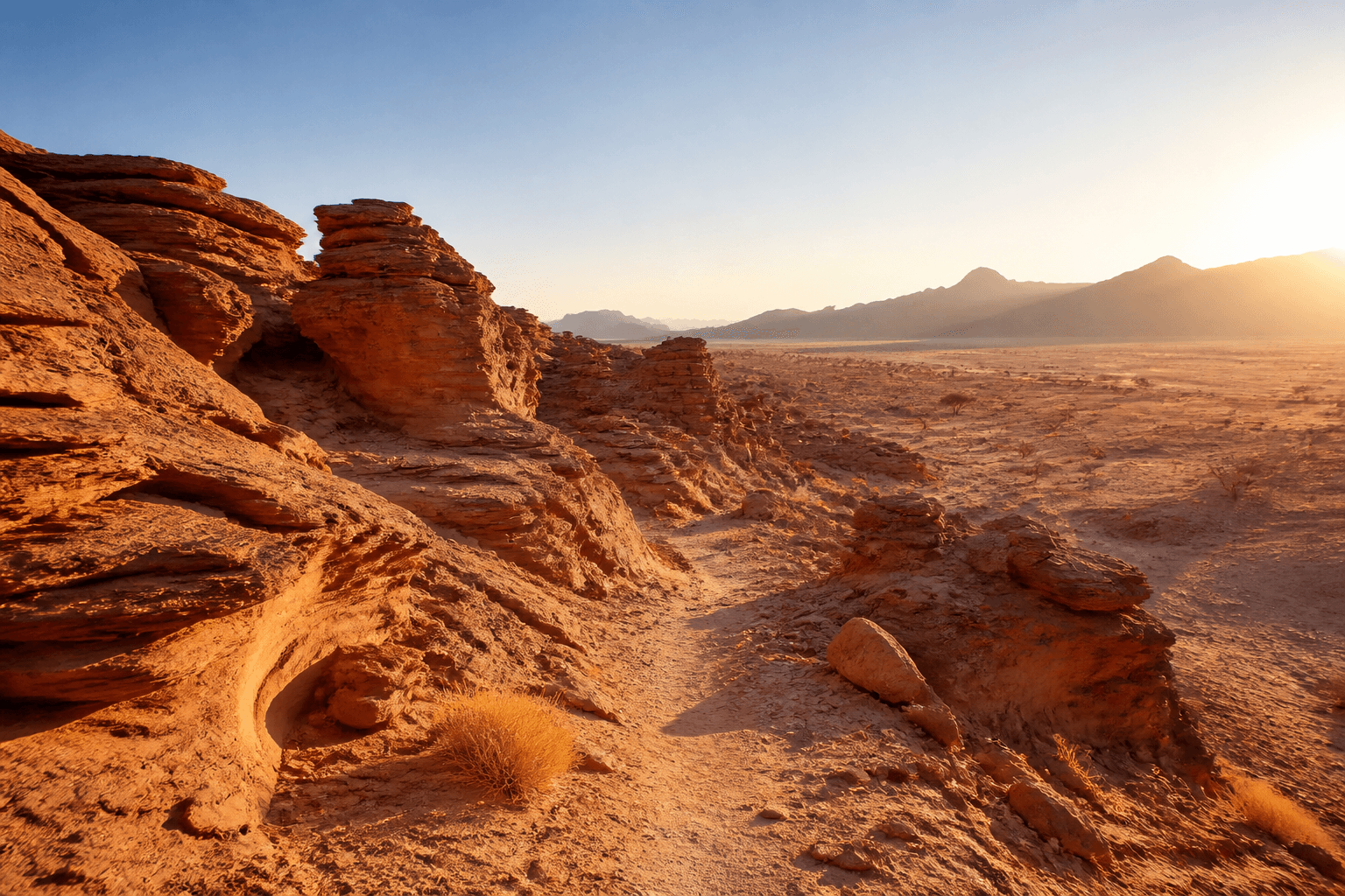 Travelers crossing warm sandstone formations in the Aïr Region