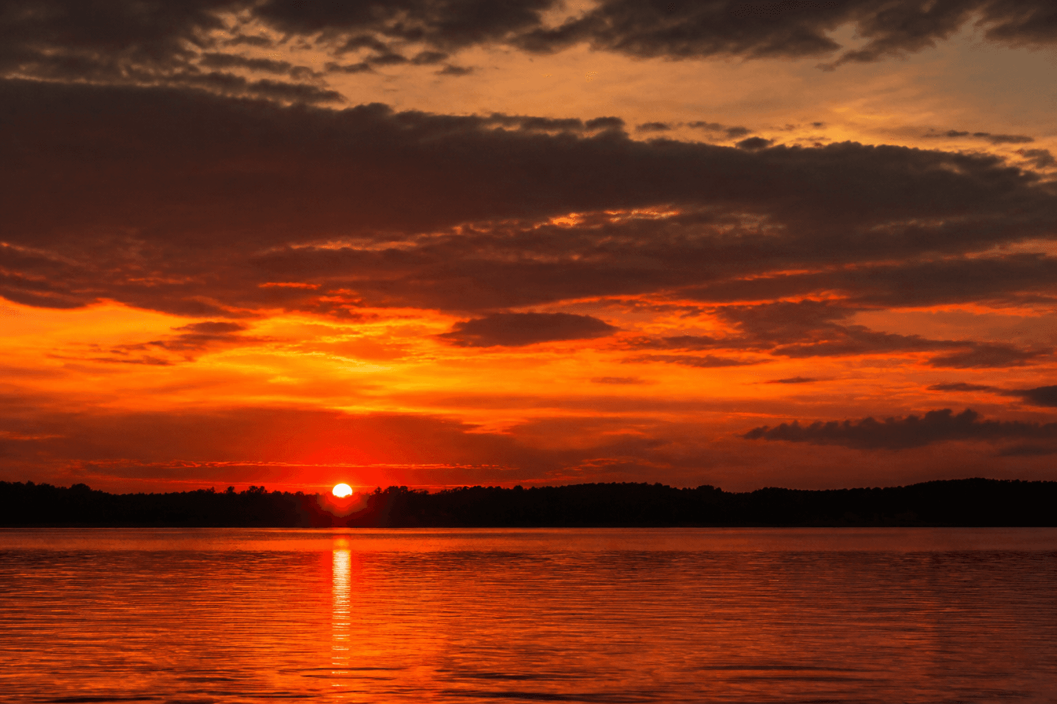 A glowing sunset over a calm lake